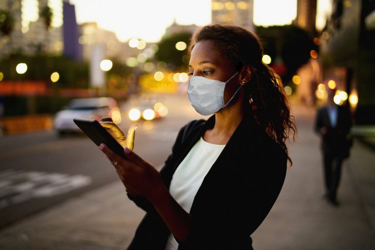 Businesswoman outdoors wearing healthcare mask. as metaphor for "zeb.market flash Q2 2020 (Issue 33 - July)"