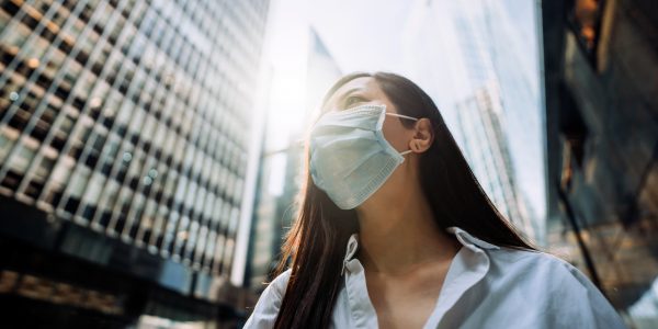 Young Asian businesswoman with protective face mask to protect and prevent from the spread of viruses as metaphor for "The banking sector between hope and fear" in zeb.market flash Q4 2020