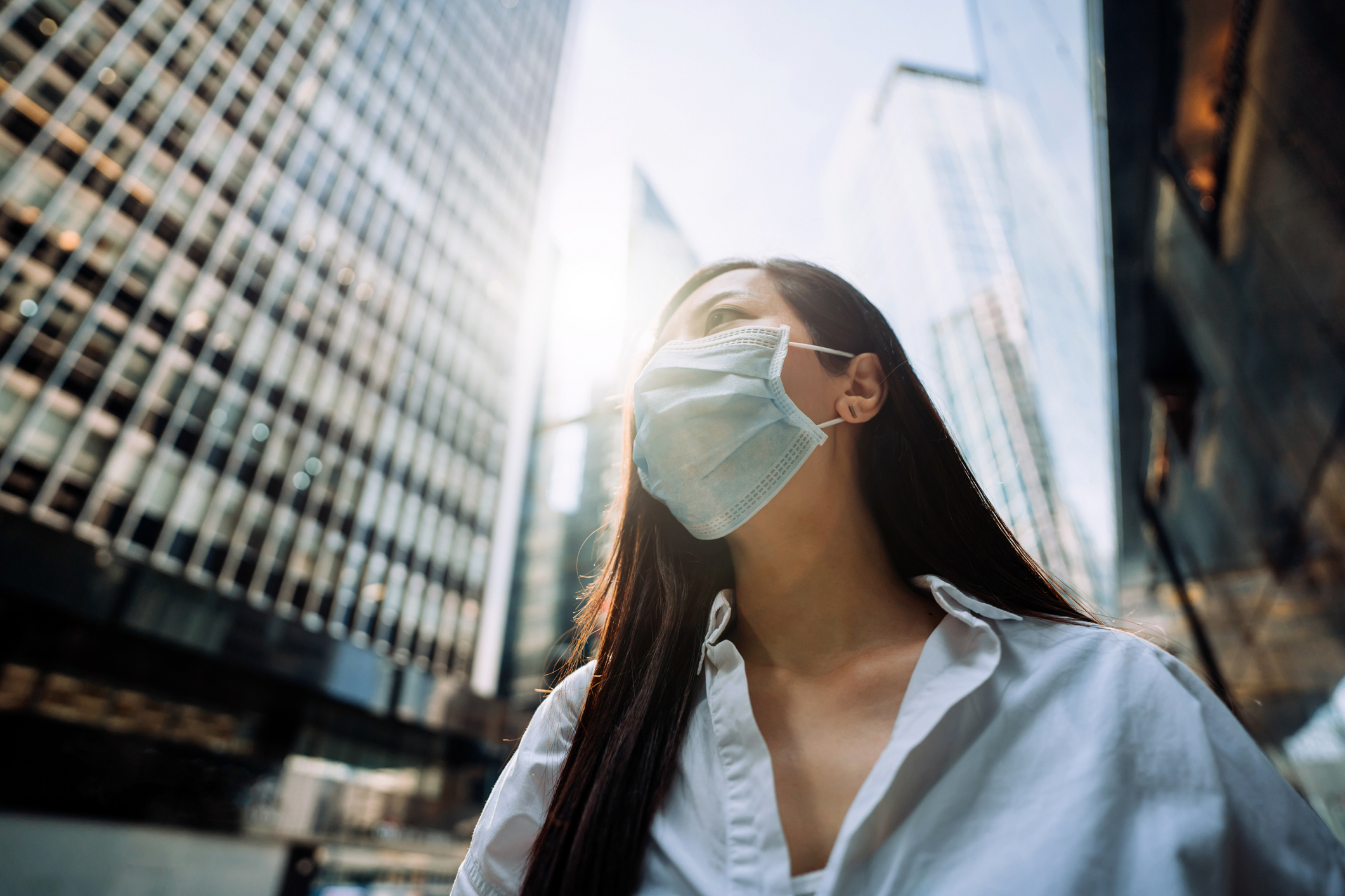 Young Asian businesswoman with protective face mask to protect and prevent from the spread of viruses as metaphor for "The banking sector between hope and fear" in zeb.market flash Q4 2020