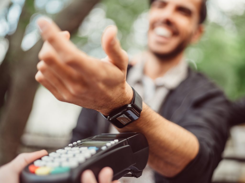 Man paying contactless as metaphor for "Future of Payments 2021–trend