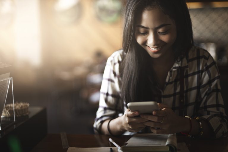 Young women holding smartphone as metaphor for the article about "Mobile banking in Italy"