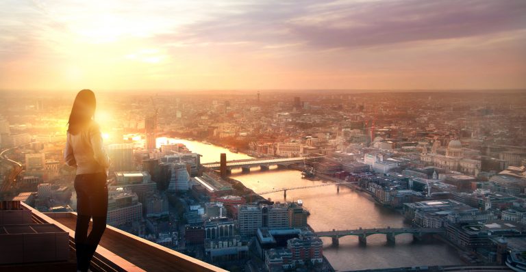 Young woman looking over the City of London as metaphor for the article "Banking sector 2021 – promising first half"